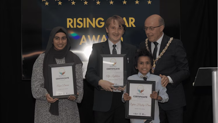 Rising Star Award winners holding certificates and smiling towards camera